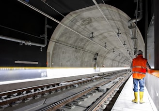 man standing beside train rail