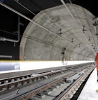 man standing beside train rail