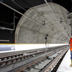 man standing beside train rail