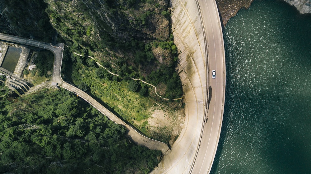 昼間のコンクリート道路を走る白色車両の航空写真