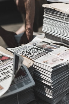 shallow focus photography of piles of newspapers