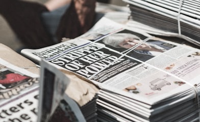 shallow focus photography of piles of newspapers