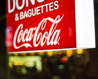 close photography of Donuts & Baguettes Coca-Cola signage