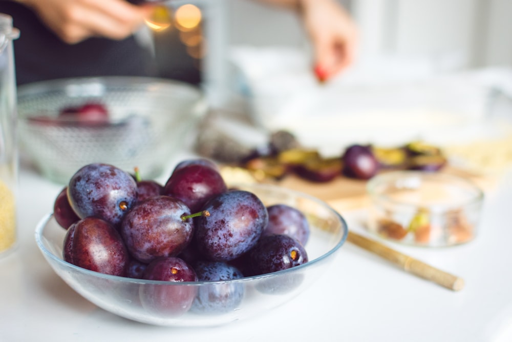 bowl of red grapes on white tabletop