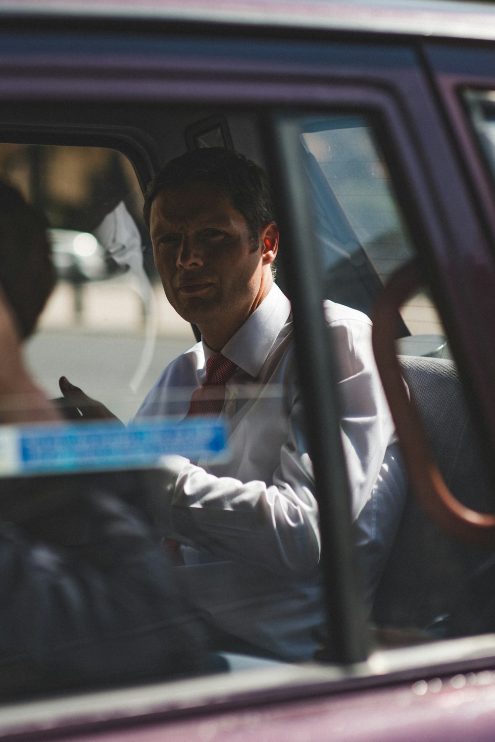 man in white dress shirt sitting inside vehicle