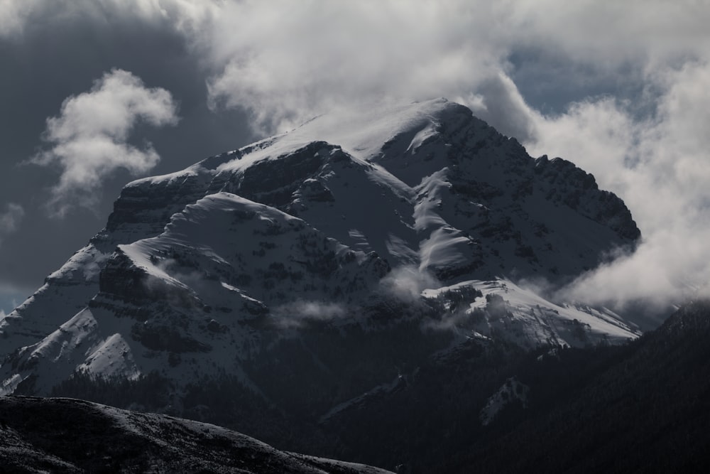 low-angle photography of mountain near clouds