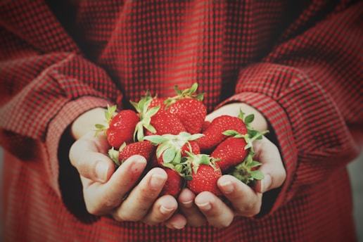 person holding strawberries
