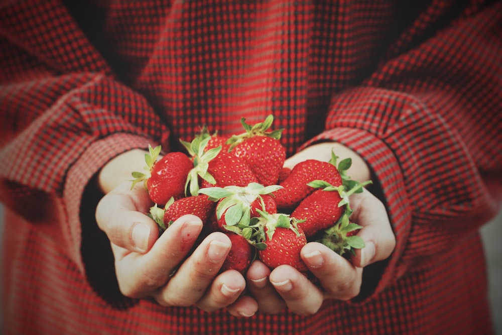 person holding strawberries