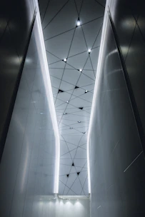 A sleek black and gold false ceiling with integrated ambient lighting in a modern living room.