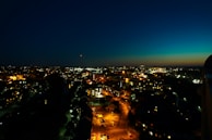 Osaka cityscape at dusk with deep navy blue sky and city lights starting to glow.