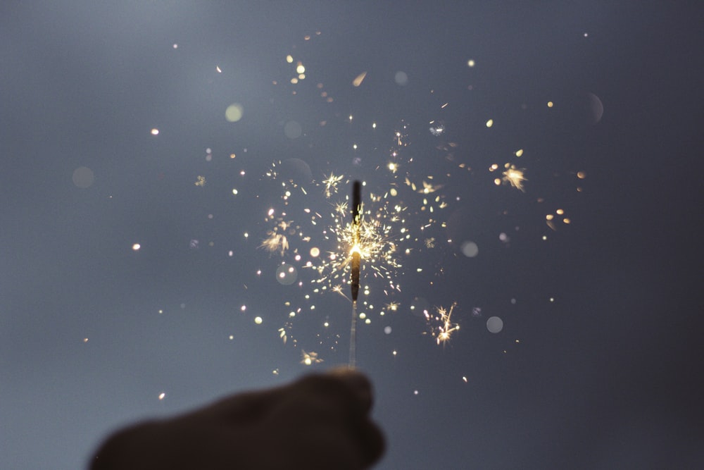 person holding lighted sparklers