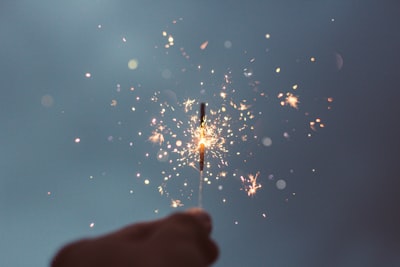 person holding lighted sparklers magic zoom background