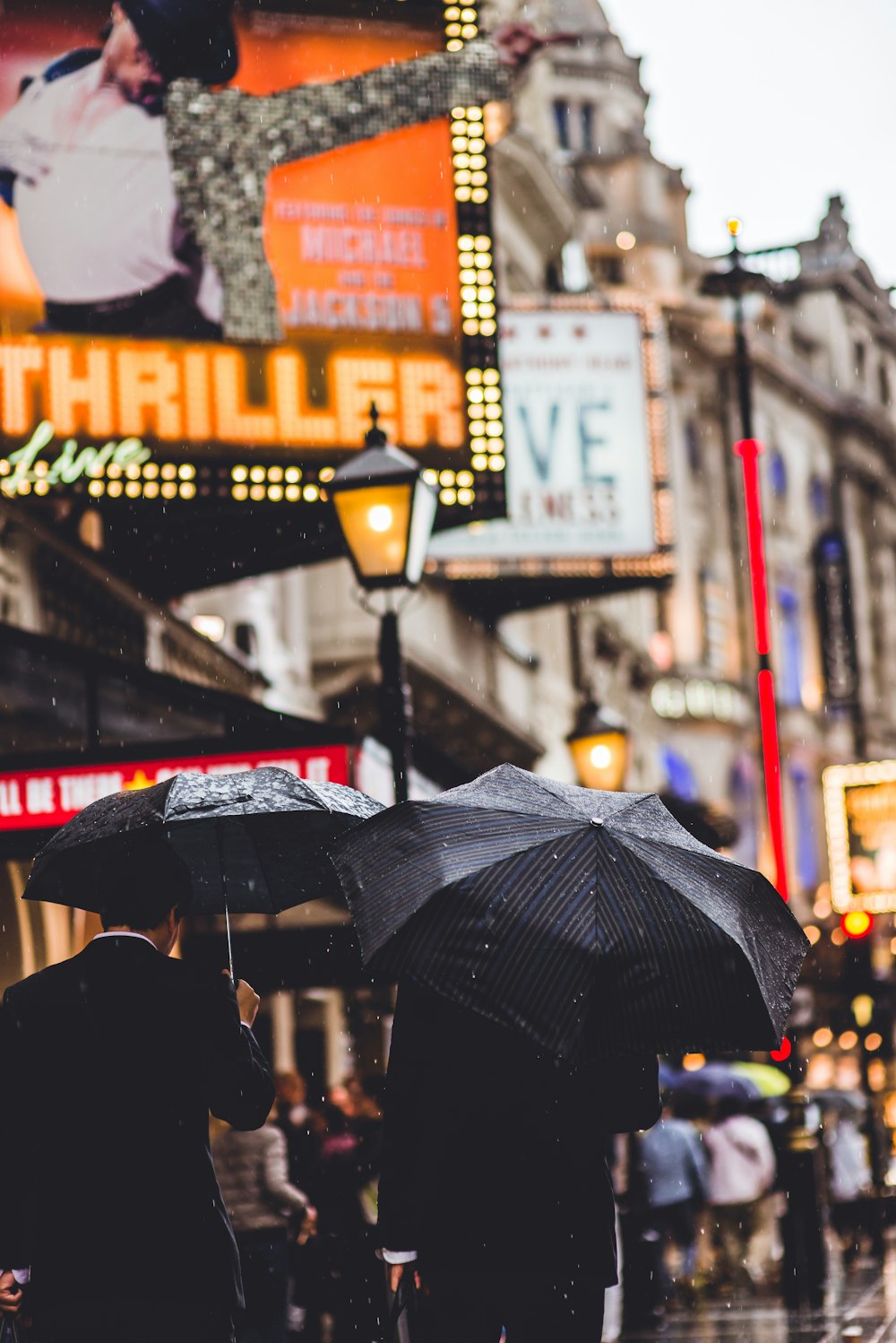 Menschen, die mit Regenschirm in der Hand gehen