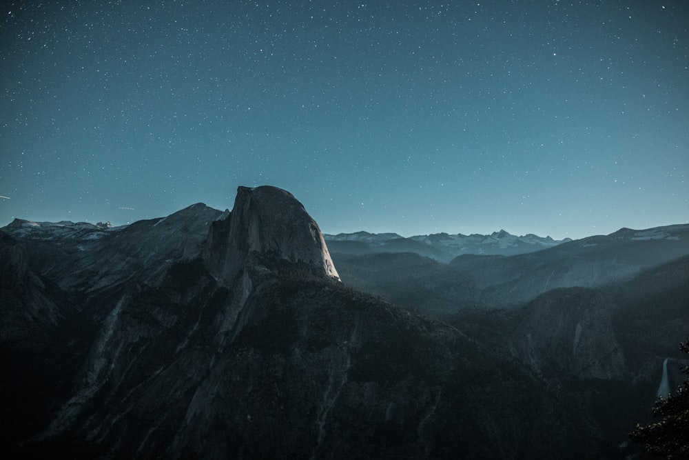 montaña negra bajo el cielo azul por la noche