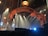 The image features a stage setup with theatrical lighting. A large, ornate archway frames the background, illuminated by multiple spotlights aiming in various directions. Some stage ropes are visible in the foreground, and a hanging lamp is situated above the archway. The overall ambiance suggests a theater or concert setting, with mist or fog possibly enhancing the lighting effects.