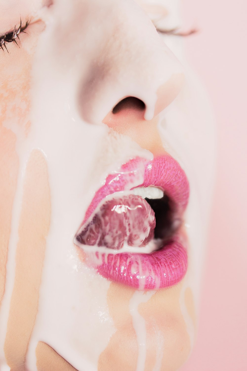 Un primer plano de la cara de una mujer con lápiz labial rosa