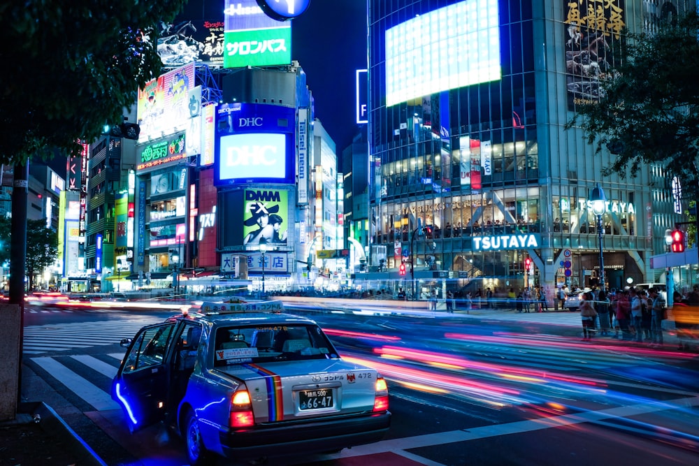 Foto timelapse de un vehículo cerca de edificios durante la noche