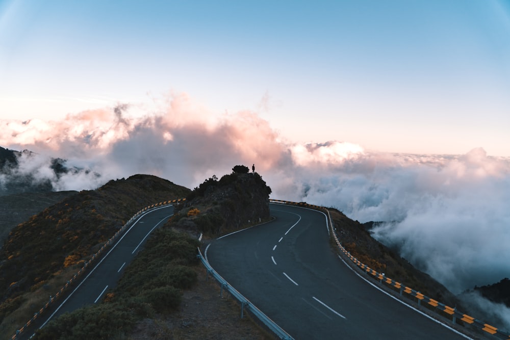 road on hill surrounded with clouds