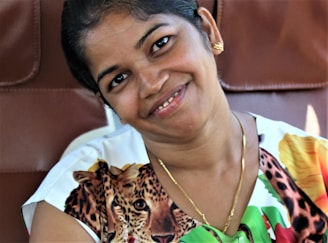 Happy customer wearing a unique Vanessa Almeida necklace in a cozy setting.