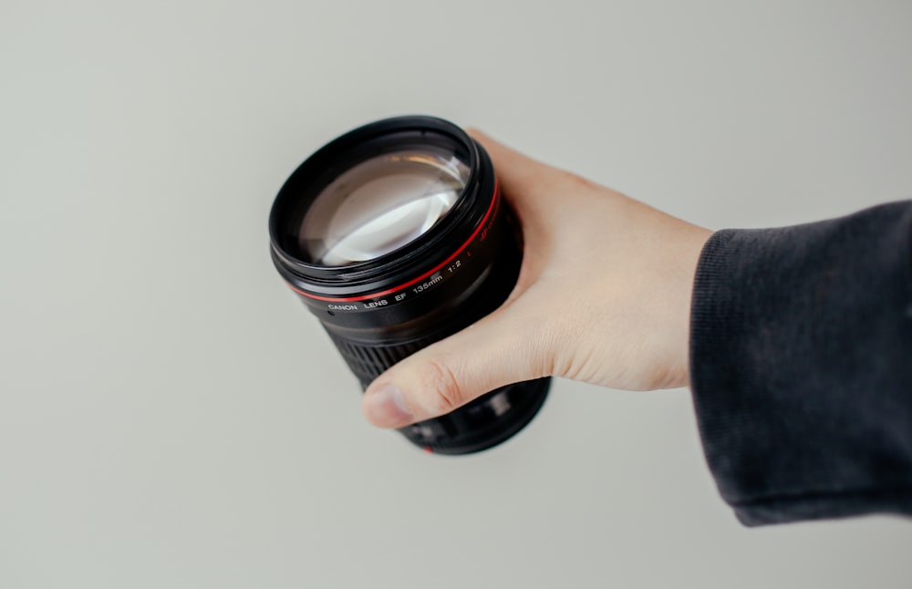 person holding black camera lens