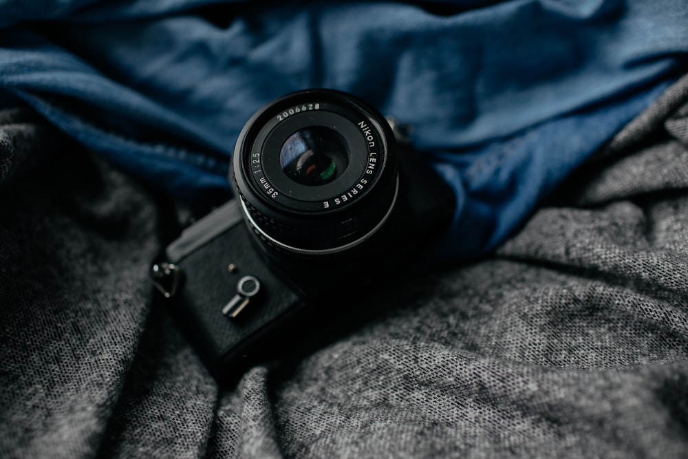 black DSLR camera on gray textile