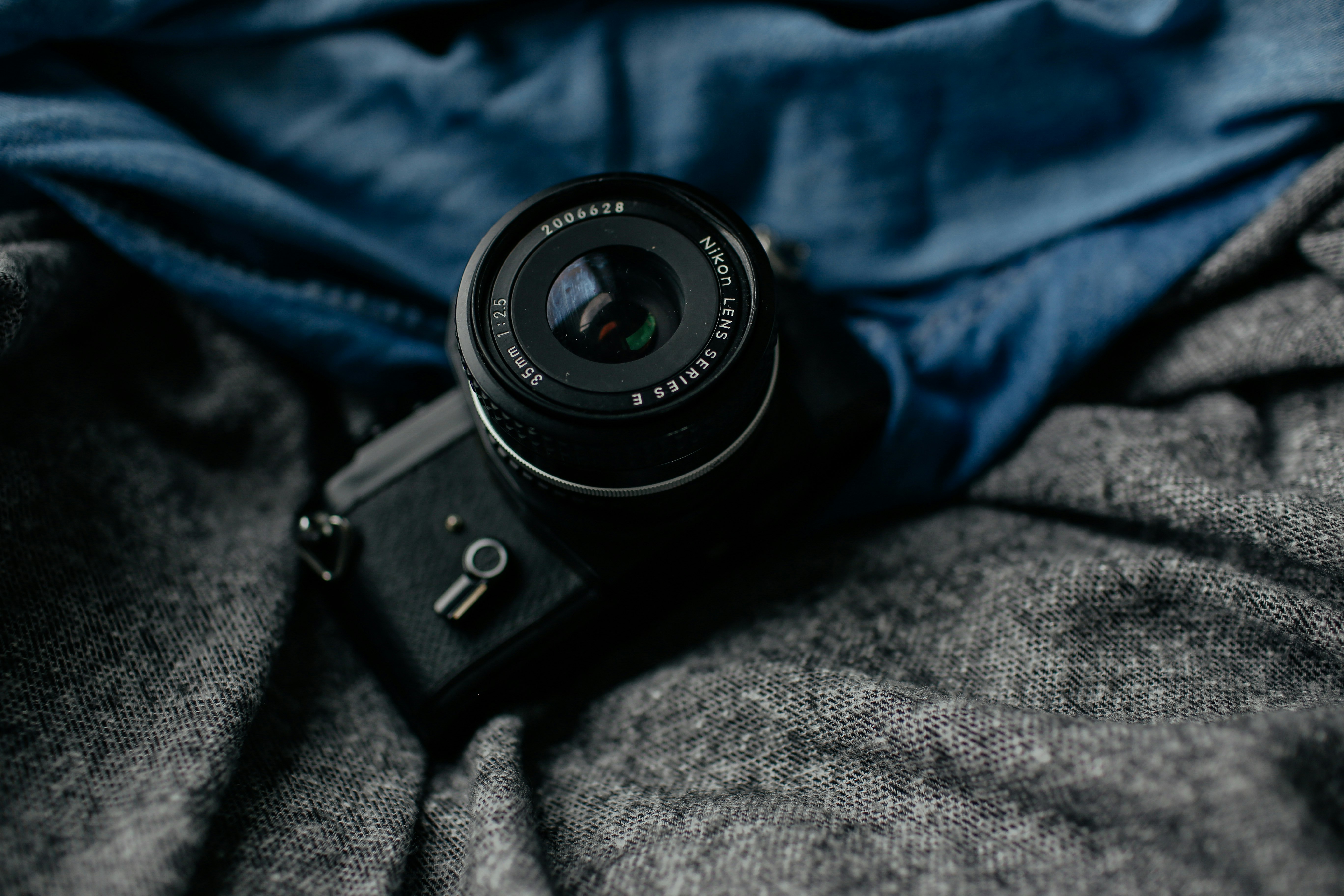 black DSLR camera on gray textile