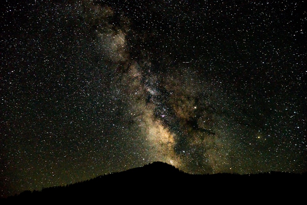 silhouette landscape photography of a mountain with stars background