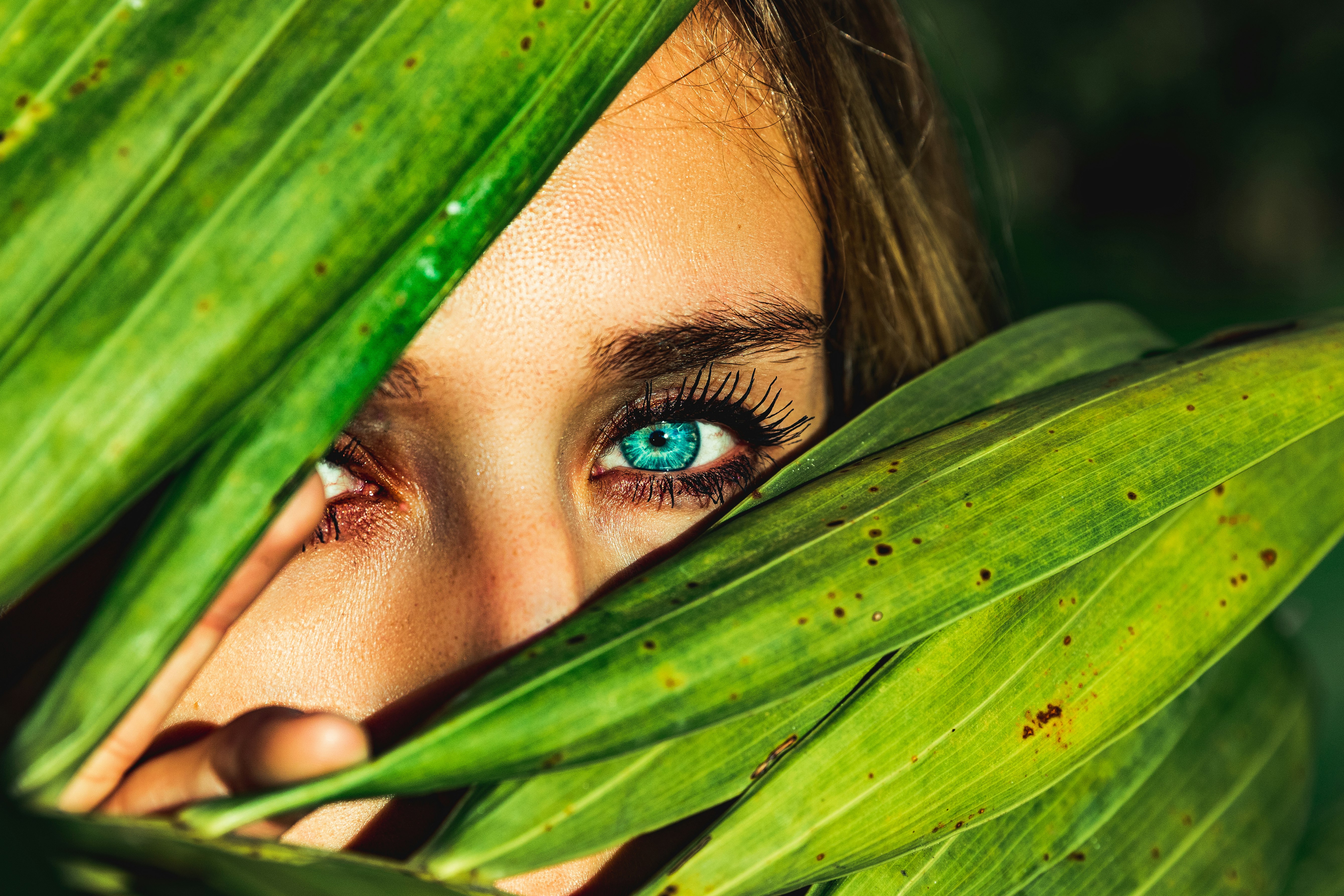 woman behind green leaves