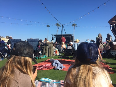 Festival-goers lounging on the grass with the ocean breeze in the background