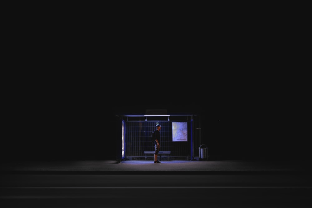 uomo in attesa sul capannone durante nightime