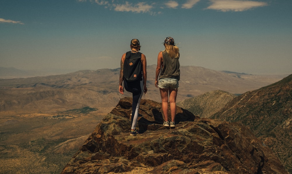 Zwei Mann und Frau stehen auf Berggipfel Foto