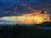 A vibrant sunset over Bayahibe beach with palm trees silhouetted against the colorful sky.
