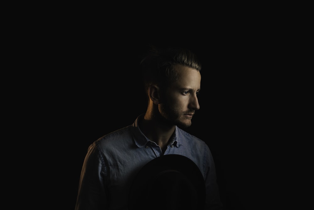 man wearing blue button-up shirt on black background