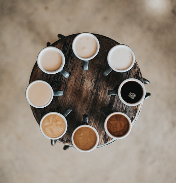 flat lay photography of eight coffee latte in mugs on round table
