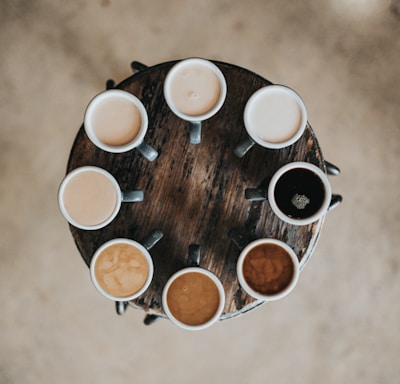 flat lay photography of eight coffee latte in mugs on round table