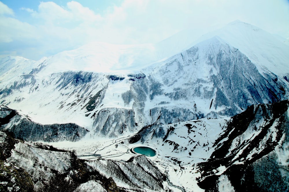 Fotografía de vista aérea de la montaña cubierta de nieve bajo el cielo nublado durante el día