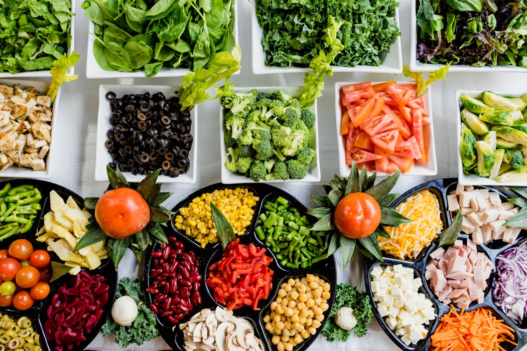 Platos con diversos alimentos saludables: proteínas, vegetales, frutas y grasas