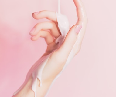 a woman's hand holding a bottle of lotion