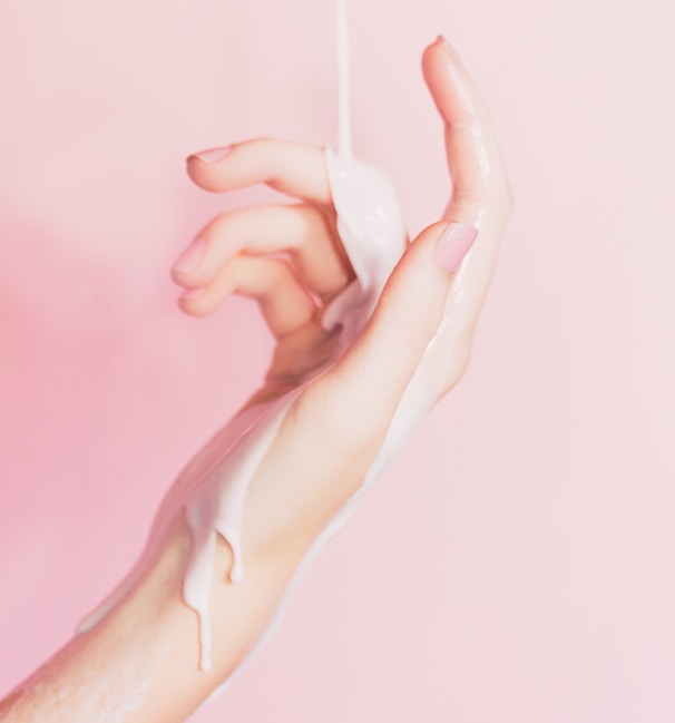 a woman's hand holding a bottle of lotion