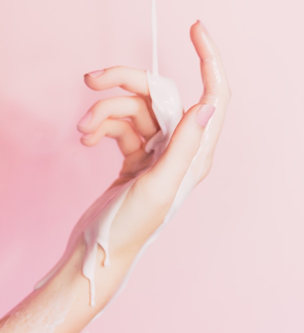 a woman's hand holding a bottle of lotion