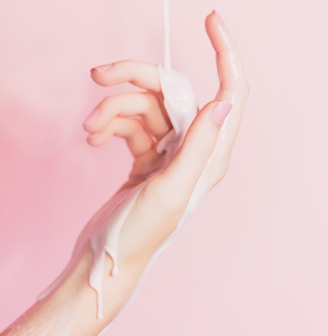 a woman's hand holding a bottle of lotion