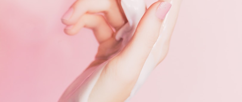 a woman's hand holding a bottle of lotion