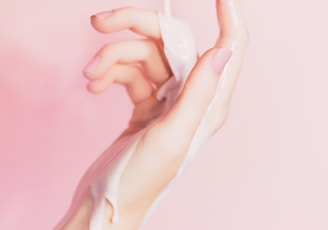 a woman's hand holding a bottle of lotion