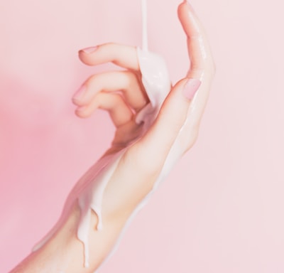 a woman's hand holding a bottle of lotion