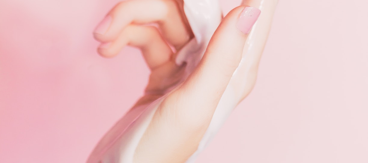 a woman's hand holding a bottle of lotion