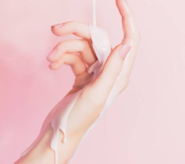 a woman's hand holding a bottle of lotion