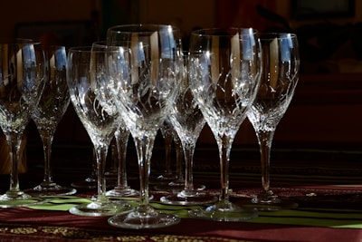 Close-up of a crystal wine glass catching soft light on a minimalist table.