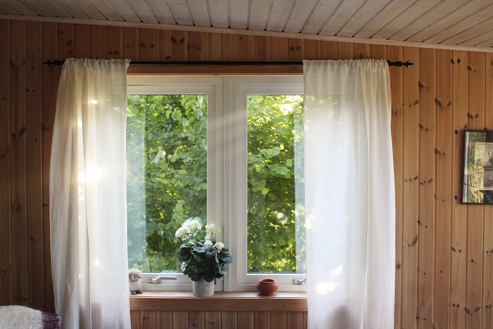 cortina branca do bolso da haste na moldura da janela