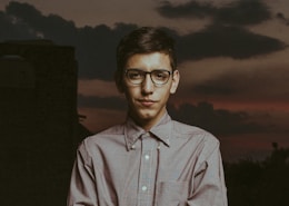 man in white and blue plaid button up shirt wearing black framed eyeglasses