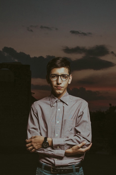 man in white and blue plaid button up shirt wearing black framed eyeglasses